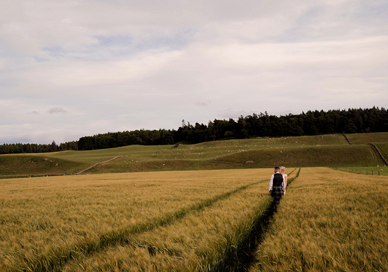 Bridre and groom walk through field